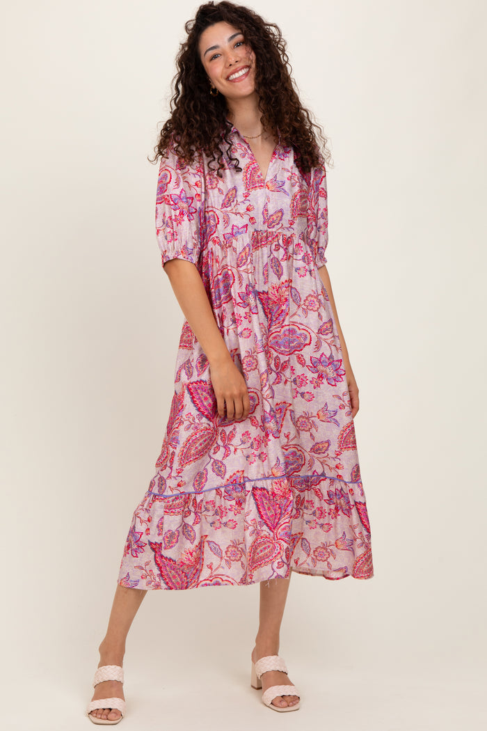 woman wearing a pink paisley printed midi dress with puff sleeves and tiered skirt