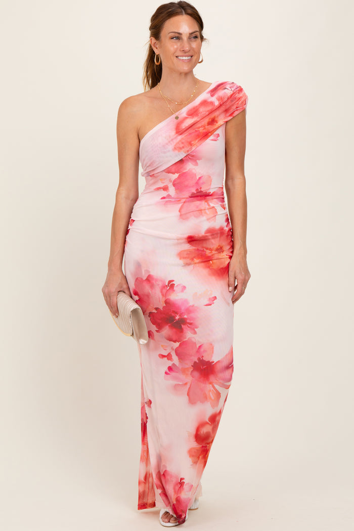 woman wearing a one-shoulder floral maxi dress in shades of pink and white, styled with a small clutch handbag