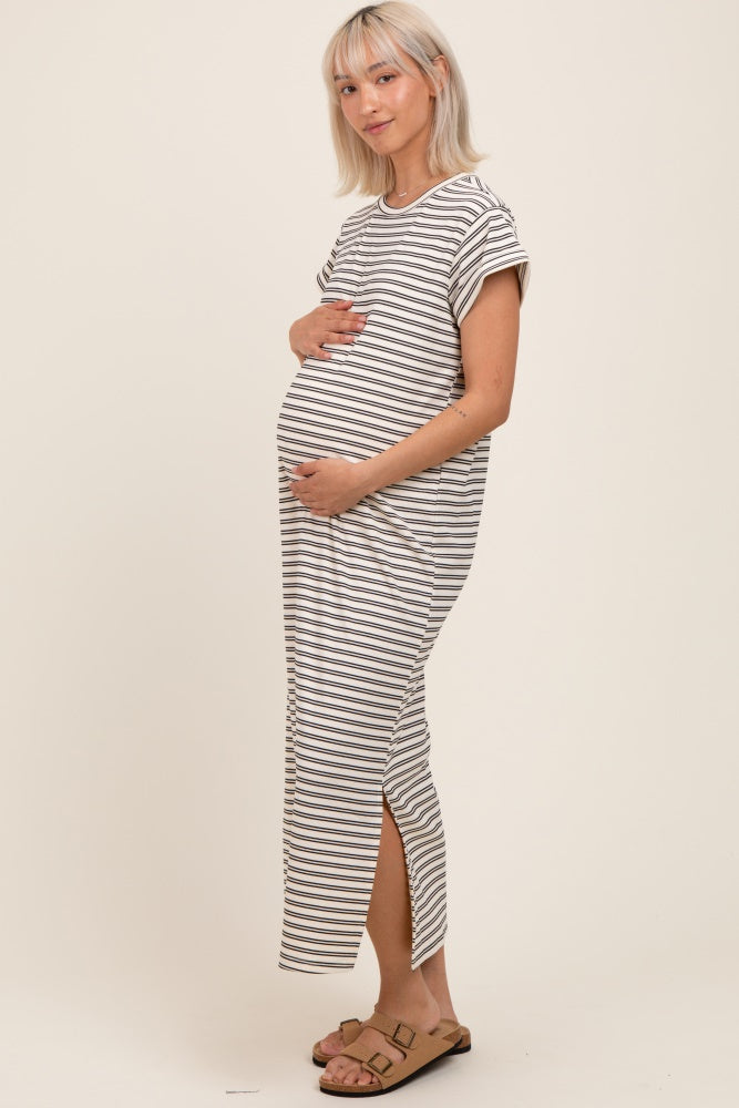 woman wearing a striped maternity maxi dress and holding her baby bump
