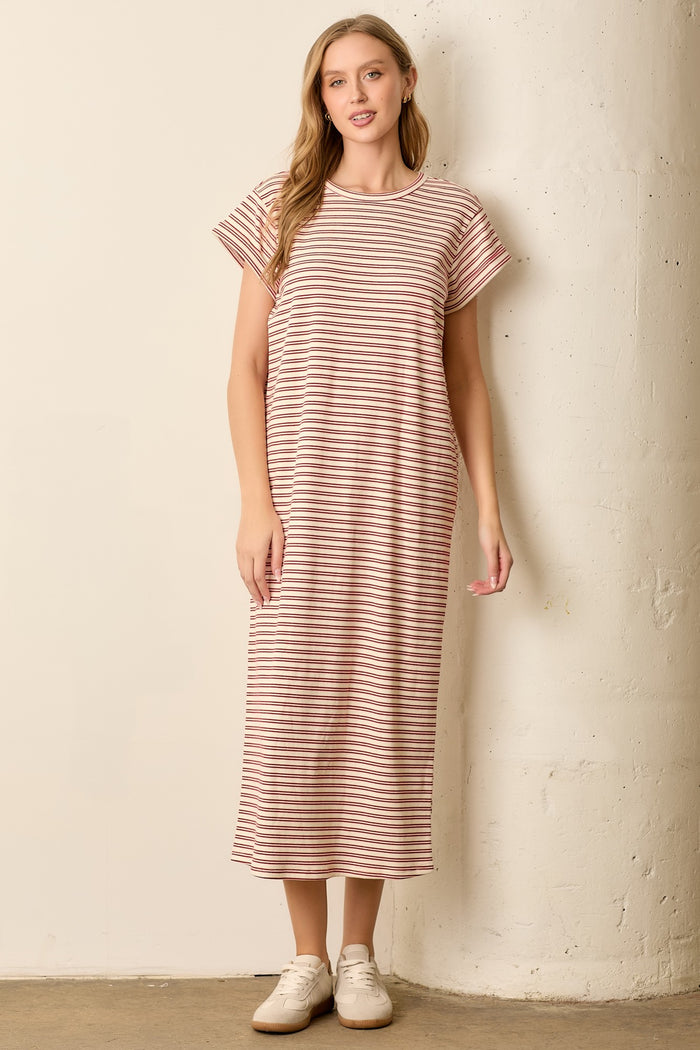 woman wearing a pink and white striped maxi dress with short sleeves and a relaxed fit