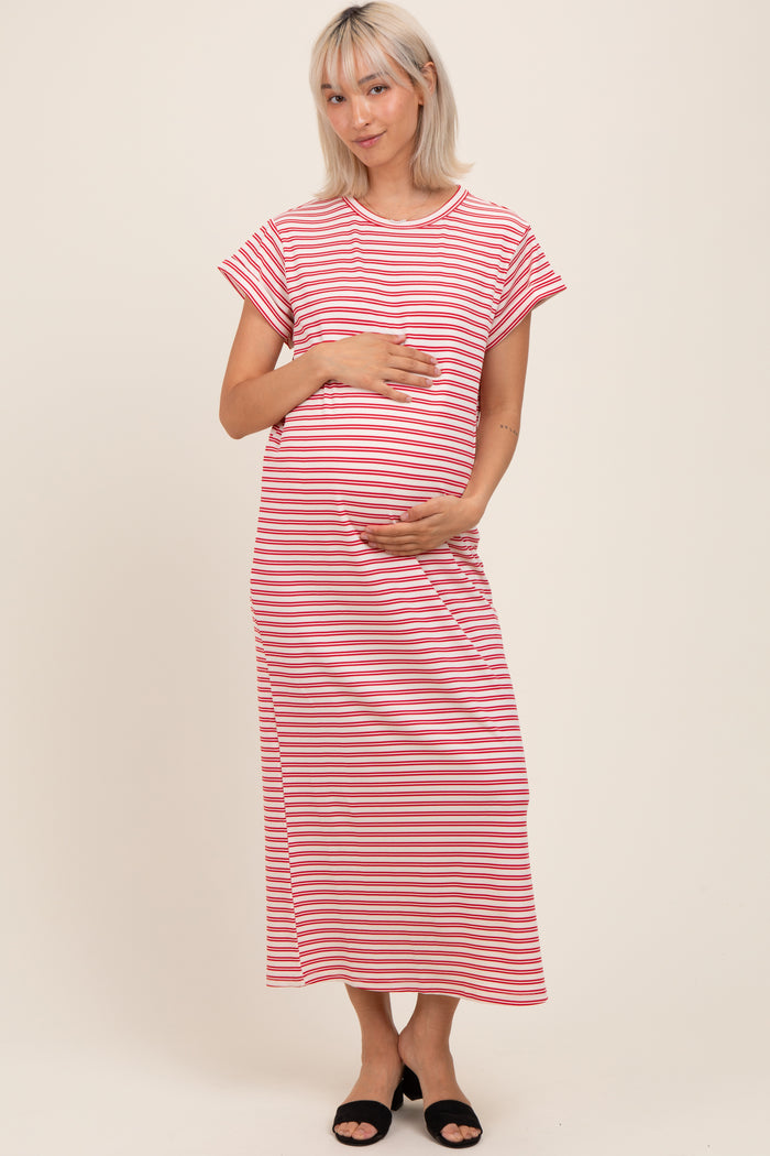 woman wearing a pink and white striped maternity maxi dress and holding her baby bump