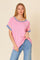 woman wearing a pink and blue striped short sleeve top with a relaxed fit paired with light blue jeans