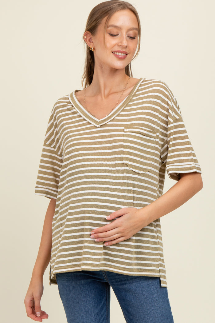 woman wearing a khaki and white striped maternity top with a v-neck and pocket, gently holding her baby bump