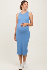 woman wearing a light blue ribbed maternity dress and holding her baby bump