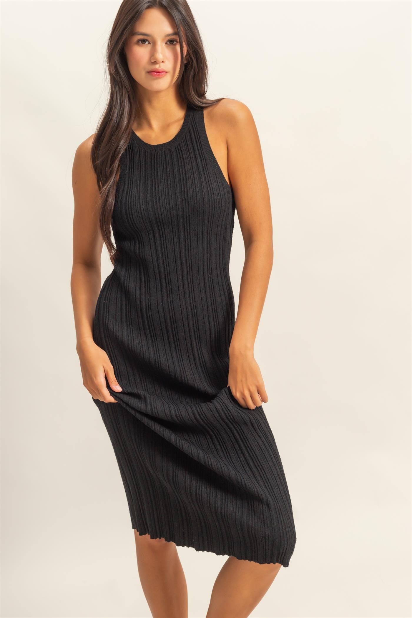 woman wearing a black ribbed knit midi dress with a sleeveless design and a fitted silhouette