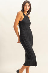 woman wearing a black ribbed midi dress with a fitted silhouette and a slight flare at the hem