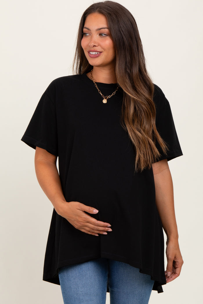 woman wearing a black short sleeve maternity top and holding her baby bump