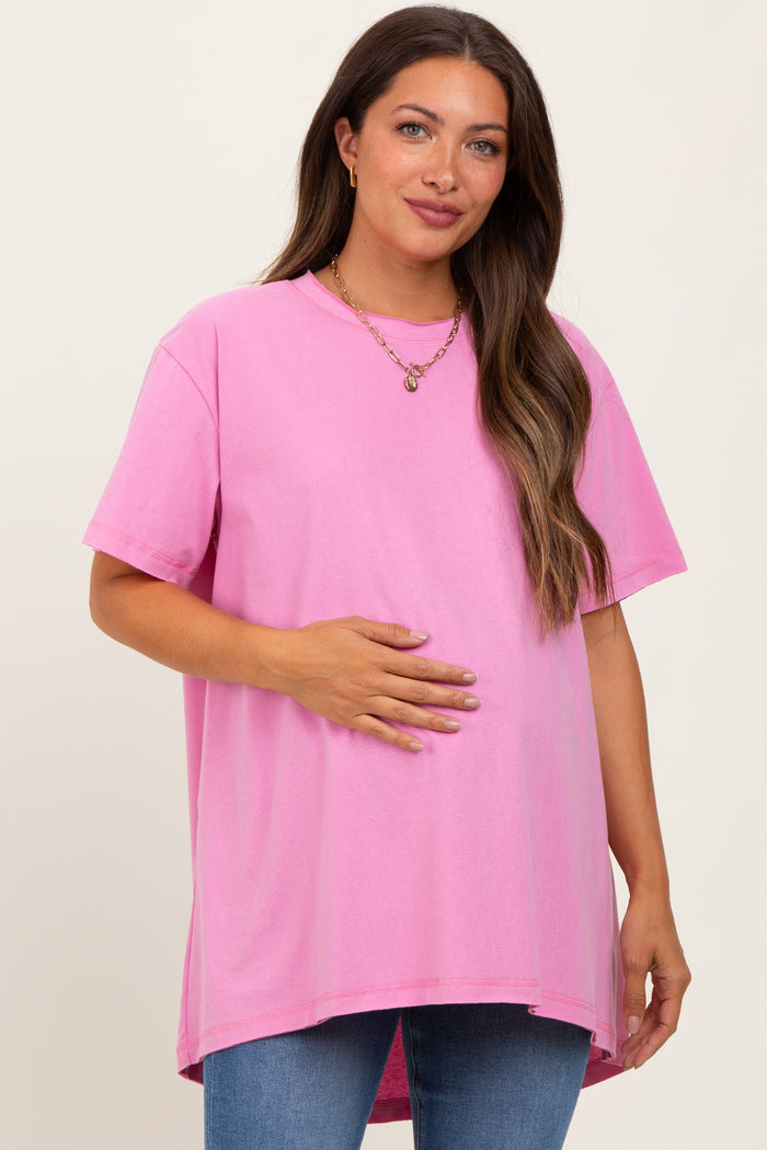 woman wearing a hot pink oversized maternity t-shirt while holding her baby bump