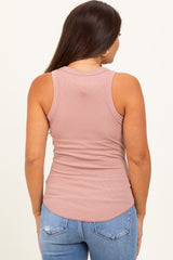 woman wearing a light pink ribbed maternity tank top and blue distressed jeans, showing the back view