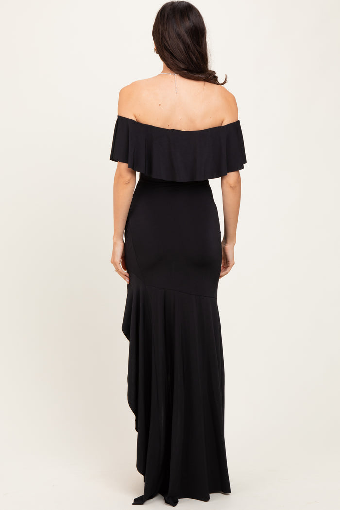 woman wearing a black off-the-shoulder mermaid gown with a ruffled neckline and shaped hemline, shown from the back
