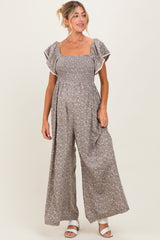 woman wearing a brown floral maternity jumpsuit with short ruffled sleeves and a smocked bodice