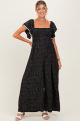 woman wearing a black floral maternity maxi dress with flutter sleeves and a square neckline