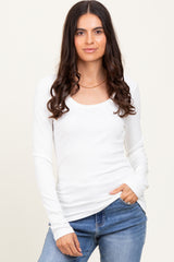 woman wearing a white long sleeve scoop neck top paired with blue jeans