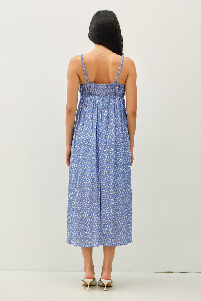 woman wearing a blue patterned maxi dress with spaghetti straps and a smocked back detail