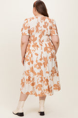 woman wearing a maternity plus white dress with orange floral pattern and tiered skirt, seen from the back