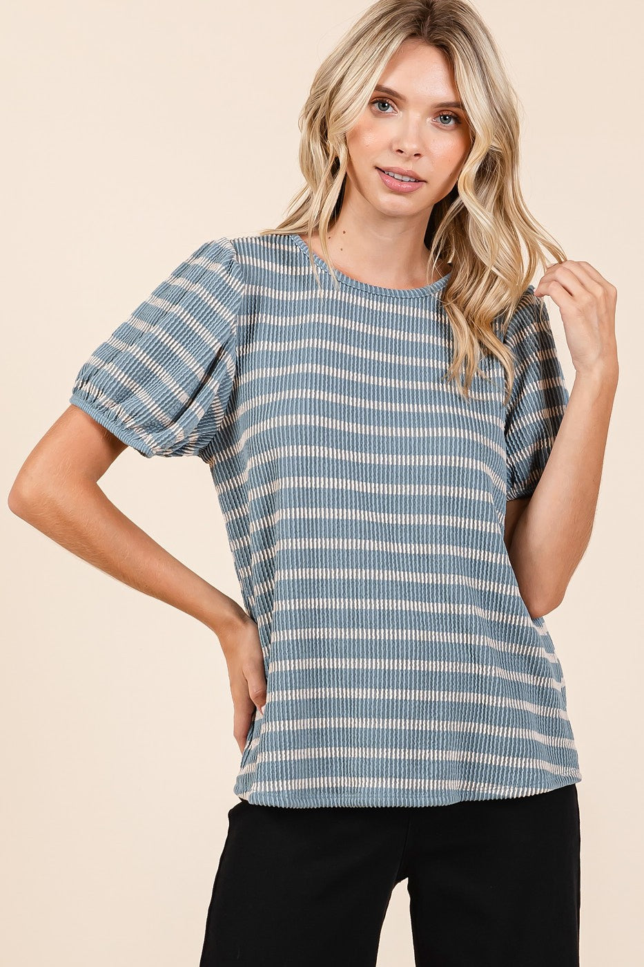 woman wearing a blue striped short sleeve top with puffed sleeves and a relaxed fit