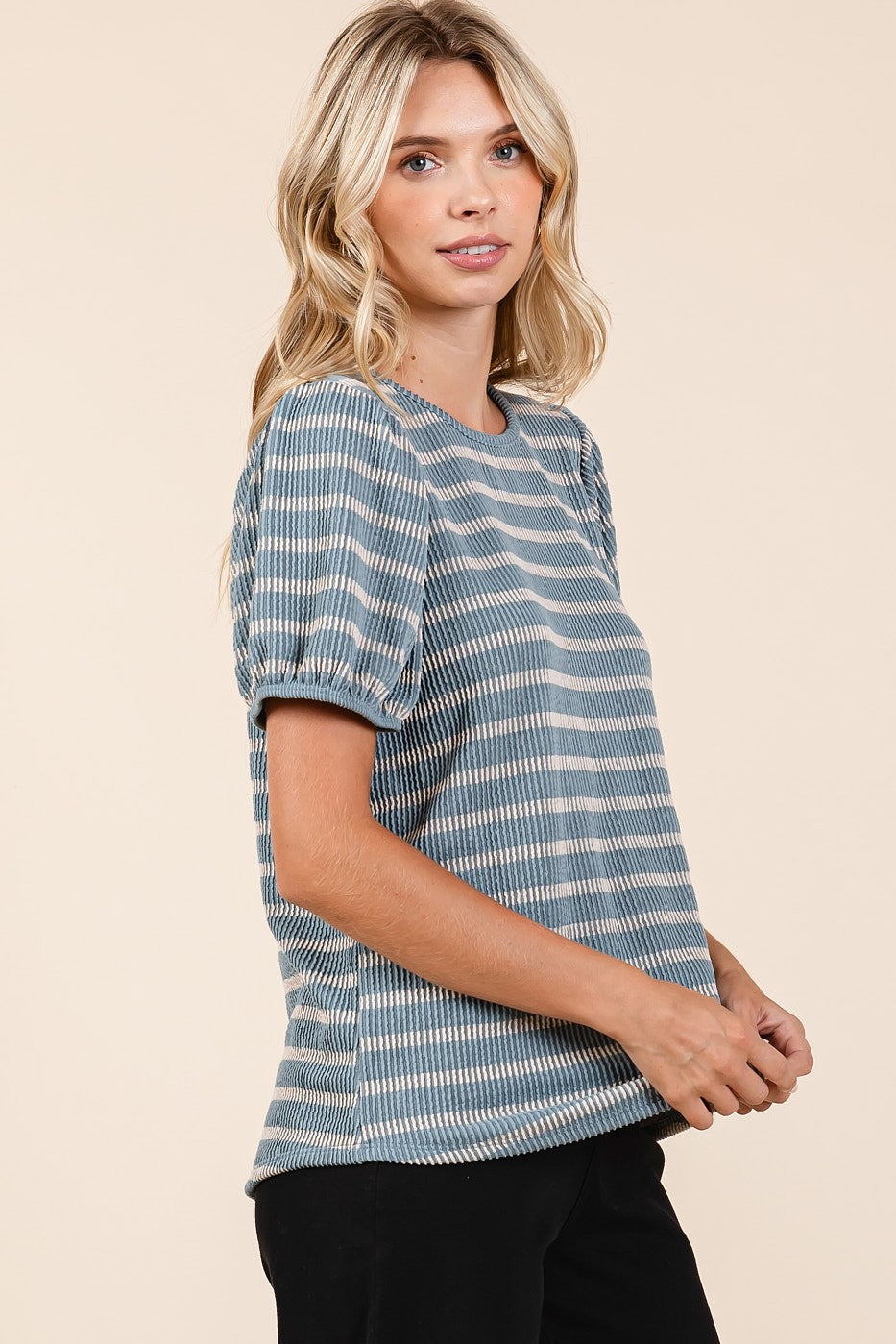 woman wearing a blue and white striped short sleeve top with puffed sleeves and a relaxed fit