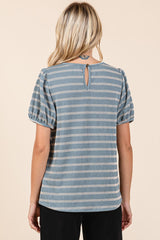 woman wearing a blue striped short sleeve top with a back keyhole detail and puffed sleeves