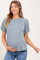 woman wearing a blue striped maternity top with puff sleeves and holding her baby bump