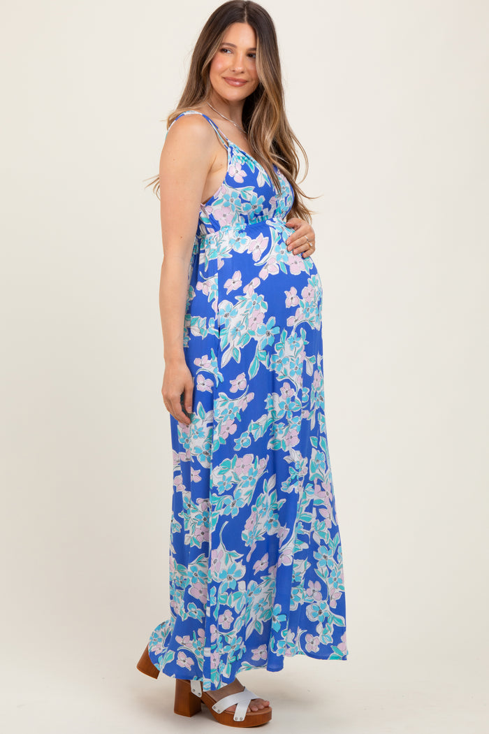woman wearing a blue floral maternity maxi dress and showcasing her baby bump