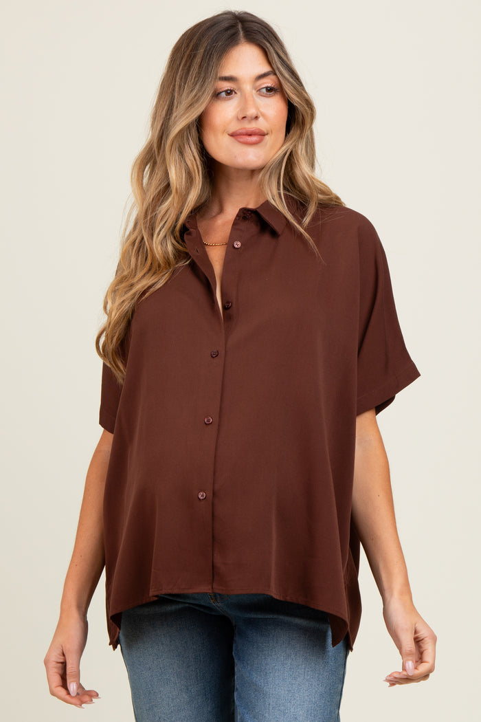 woman wearing a brown short sleeve button-up maternity top with a relaxed fit and styled with blue jeans