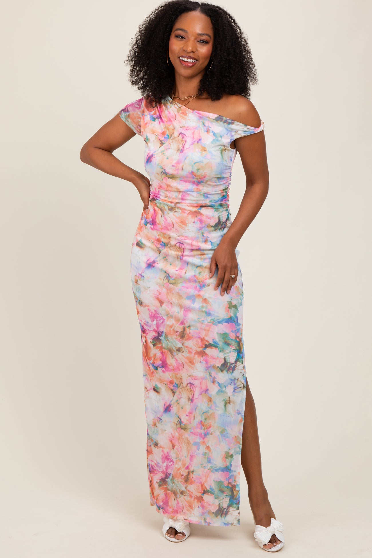 woman wearing a colorful floral off-the-shoulder maxi dress with a side slit and a fitted silhouette