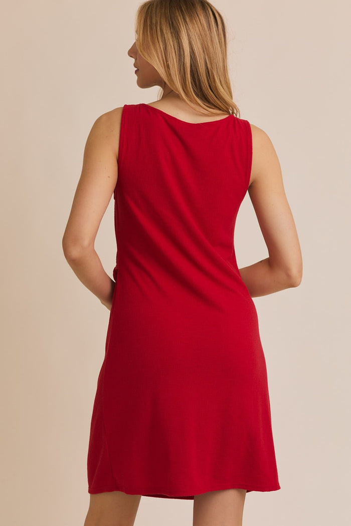 woman wearing a red sleeveless swing dress seen from the back