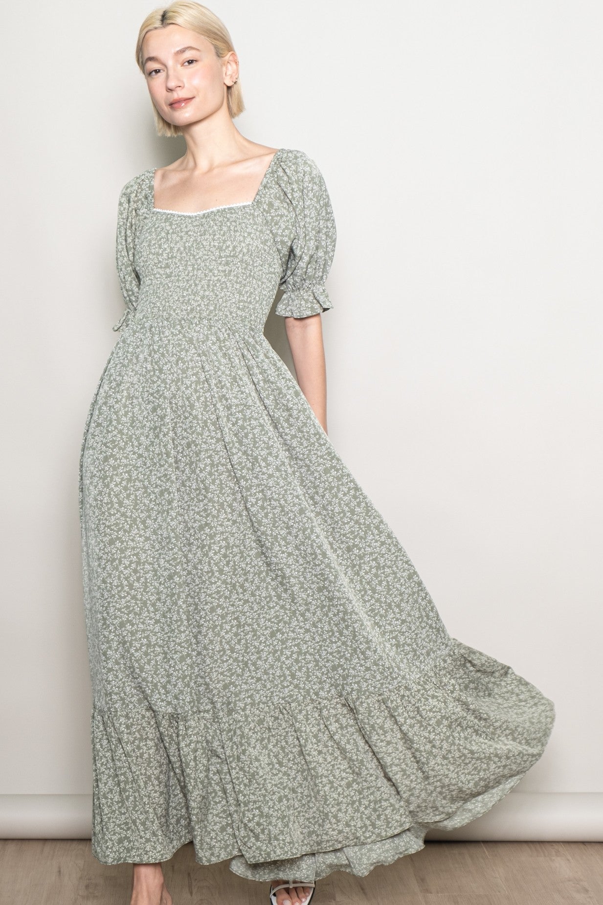 woman wearing a green floral maxi dress with puff sleeves and a square neckline, styled with a flowing skirt