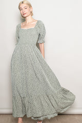 woman wearing a green floral maxi dress with puff sleeves and a square neckline, styled with a flowing skirt