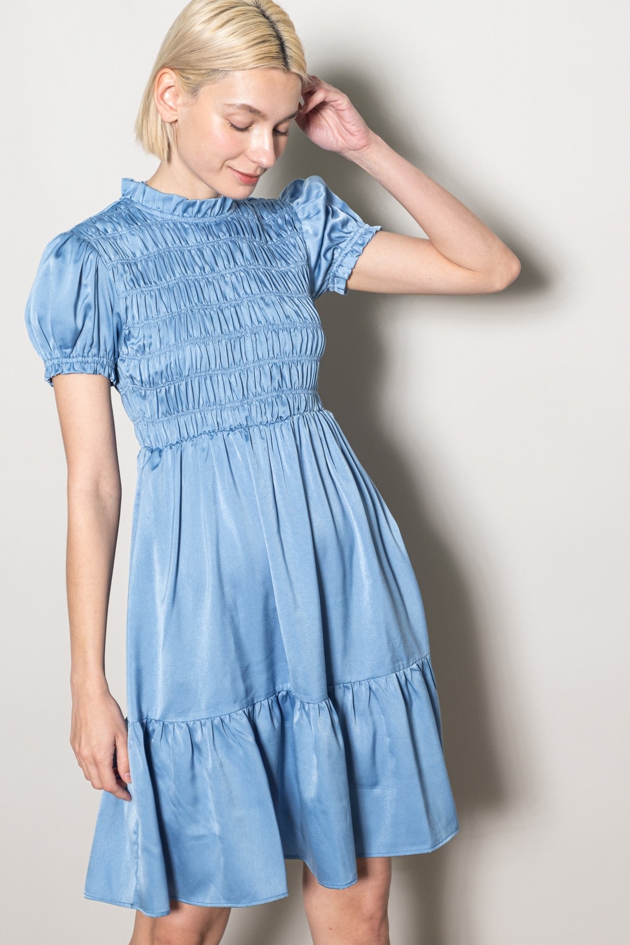 woman wearing a light blue short sleeve smocked dress with a tiered skirt and puffed sleeves