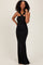 woman wearing a black floor-length dress with a twisted bodice and fitted silhouette