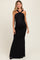 woman wearing a black maxi maternity dress with a halter neck and ruching detail accentuating a baby bump