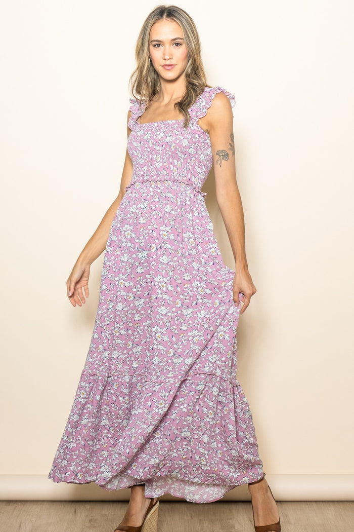 woman wearing a lavender floral maxi dress with ruffled straps and a flowing skirt