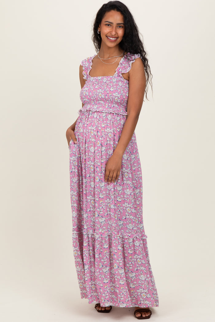 woman wearing a pink floral maternity maxi dress with ruffled straps and a baby bump visible