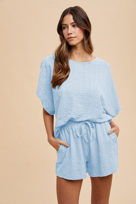 woman wearing a light blue textured short set with a relaxed fit and drawstring waistband