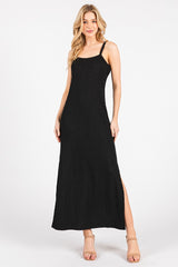 woman wearing a black smocked maxi dress with side slits and thin straps