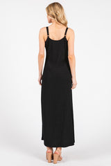 woman wearing a black maxi dress with adjustable straps and a fitted silhouette, viewed from the back