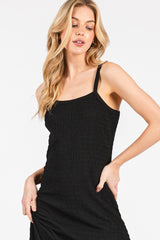 woman wearing a black smocked bodycon dress with spaghetti straps