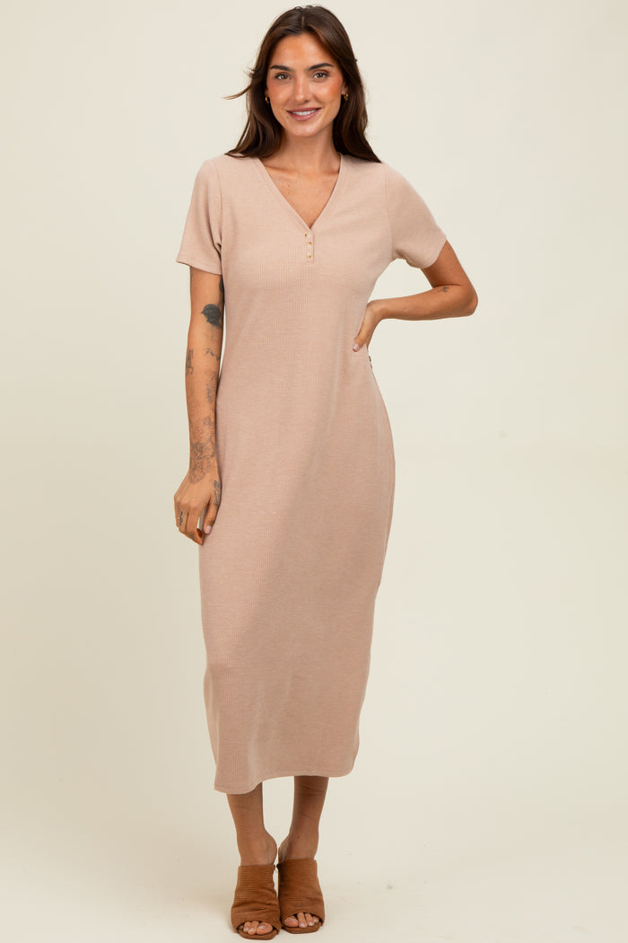woman wearing a light beige short sleeve ribbed maxi dress with a v-neck and button details, standing and smiling