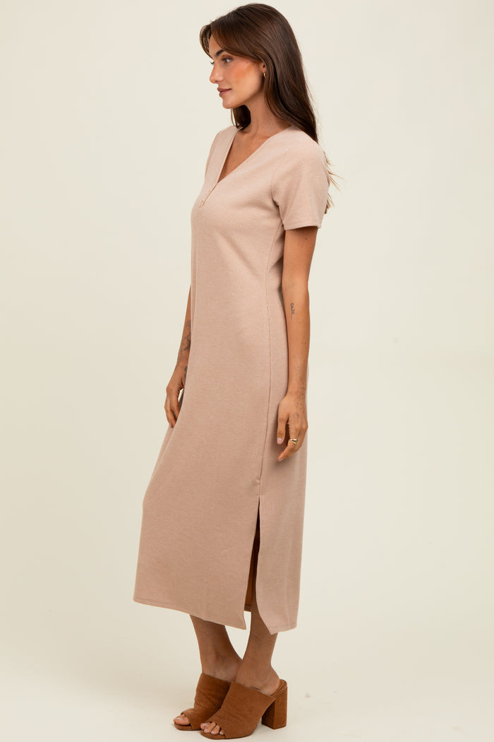 woman wearing a beige short sleeve maxi dress with a v-neck and side slit, standing against a neutral background