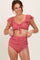 woman wearing a pink ribbed bikini top with ruffled sleeves and high-waisted bikini bottoms