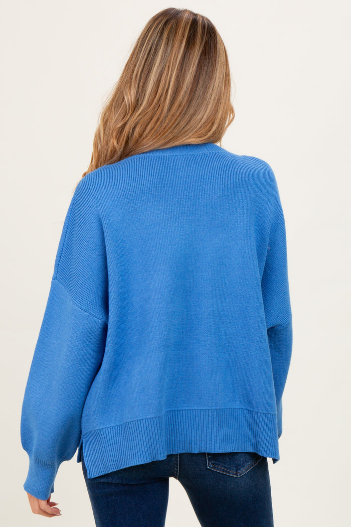 woman wearing a soft blue oversized maternity sweater with long sleeves and a relaxed fit