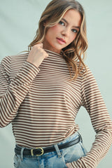 woman wearing a brown and beige striped long sleeve top with a high neckline and loose fit