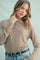 woman wearing a brown and beige striped long sleeve top with a high neckline and loose fit