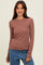woman wearing a dusty rose long sleeve ribbed top paired with blue jeans