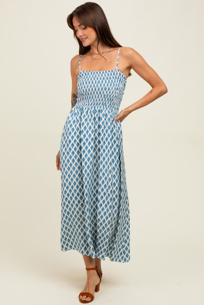 woman wearing a blue and white patterned maxidress with smocked bodice and spaghetti straps