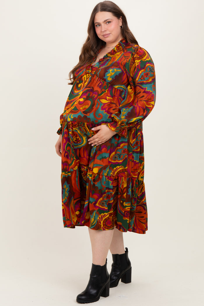 woman wearing a colorful floral maternity dress with a baby bump, paired with black ankle boots
