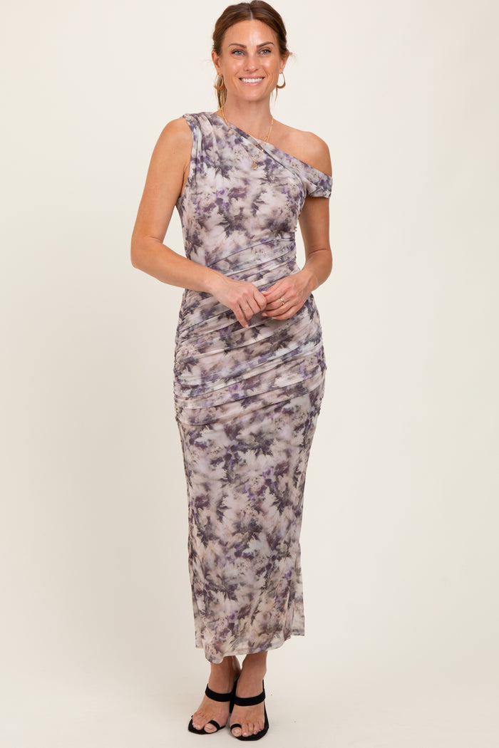 woman wearing a one-shoulder tie-dye maxi dress with ruching details and a fitted silhouette