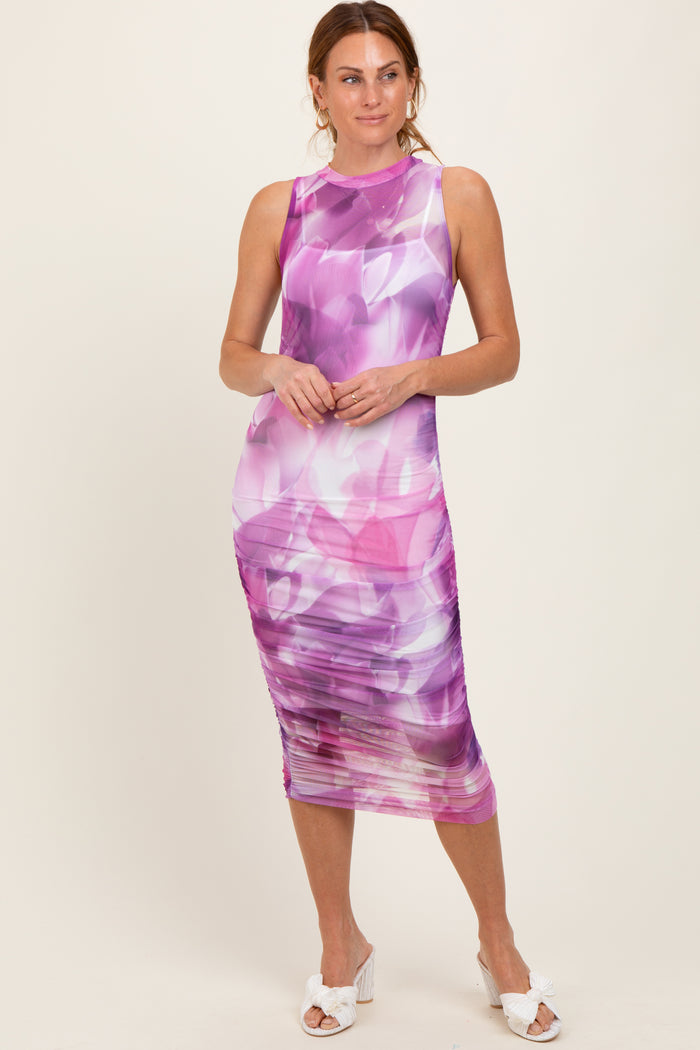 woman wearing a purple floral print midi dress with ruching detail and a sleeveless design