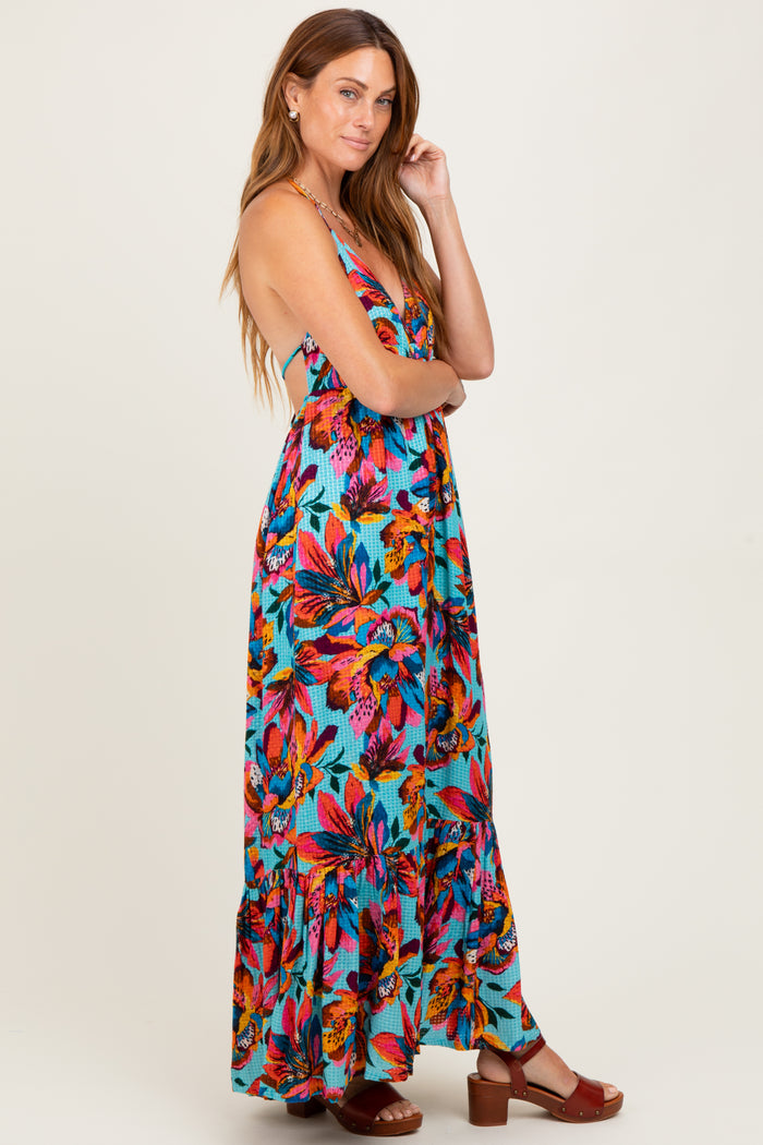 woman wearing a colorful floral maxi dress with a ruffled hem and a low back